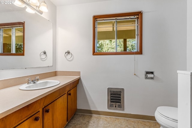 bathroom featuring vanity, toilet, tile patterned floors, and heating unit