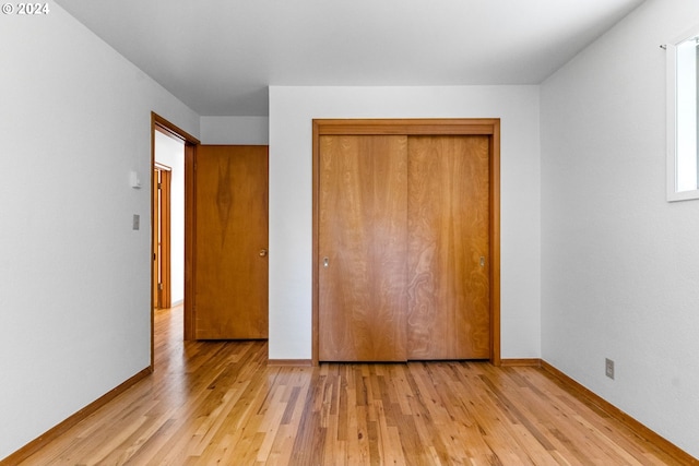 unfurnished bedroom featuring a closet and light hardwood / wood-style flooring