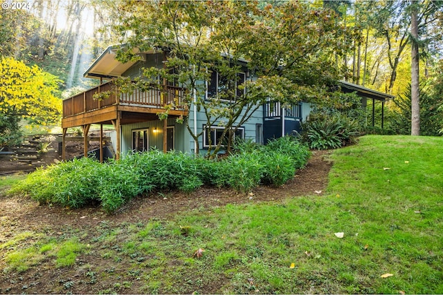 back of property with a wooden deck and a lawn