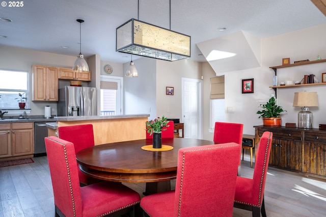 dining area featuring plenty of natural light, sink, and light wood-type flooring