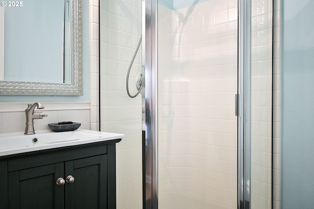 bathroom with a shower with shower door and vanity