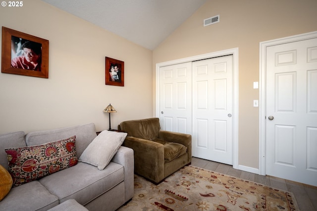 living room featuring lofted ceiling and light wood-type flooring