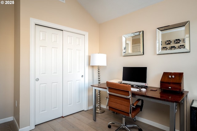 office area featuring light wood-type flooring and vaulted ceiling