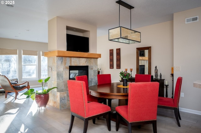 dining space featuring a tiled fireplace