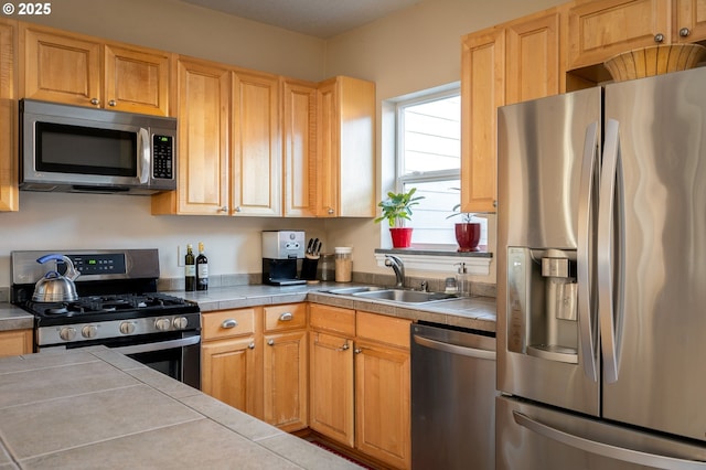 kitchen featuring sink, appliances with stainless steel finishes, and tile countertops