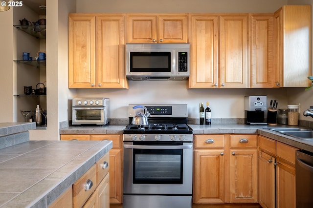 kitchen featuring light brown cabinets, sink, tile countertops, and stainless steel appliances