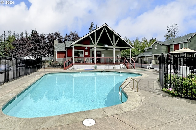 view of swimming pool featuring ceiling fan and a patio area