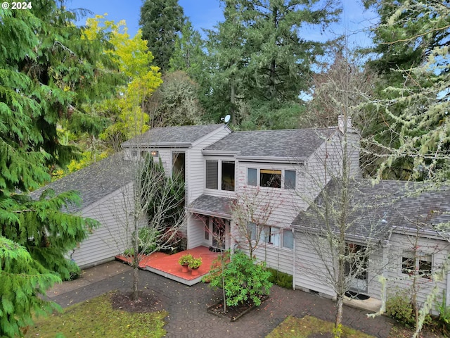 view of front of property with a shingled roof and a chimney