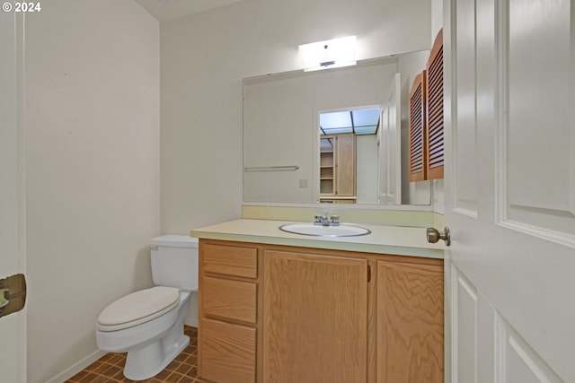 half bath with toilet, tile patterned flooring, and vanity