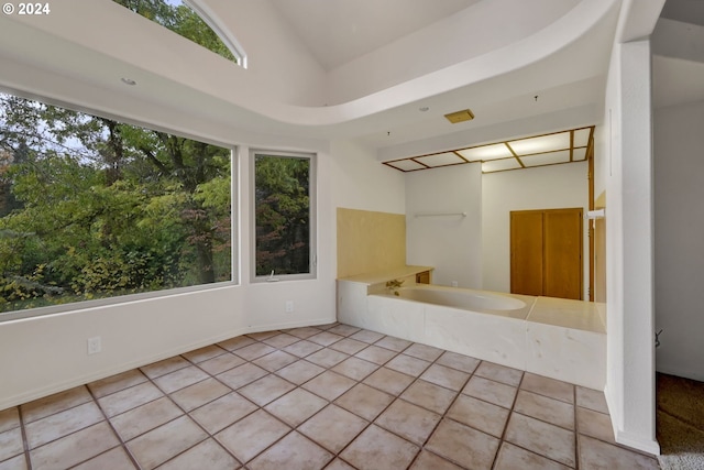 bathroom featuring lofted ceiling, plenty of natural light, and tile patterned floors