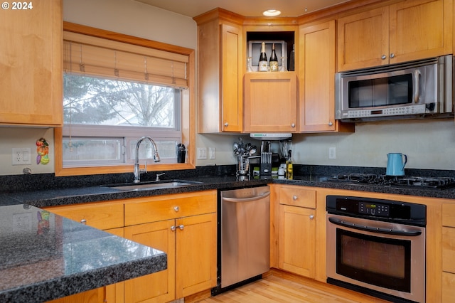 kitchen with light hardwood / wood-style floors, sink, and appliances with stainless steel finishes