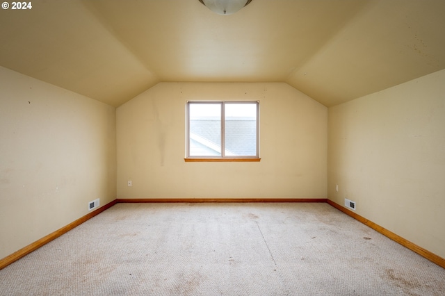 additional living space with light carpet and lofted ceiling