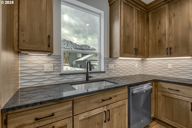 kitchen with dark stone countertops, sink, and tasteful backsplash