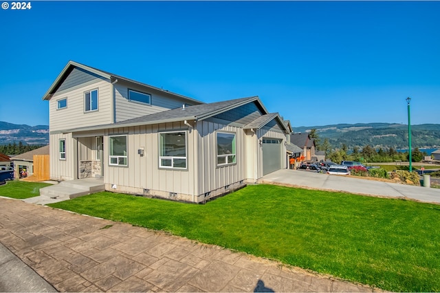 exterior space featuring a mountain view, a garage, and a yard