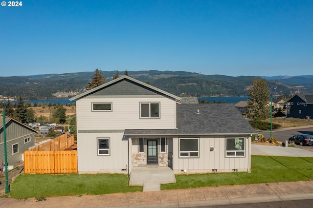 front facade featuring a mountain view and a front yard