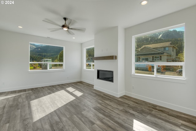 unfurnished living room featuring ceiling fan and wood-type flooring