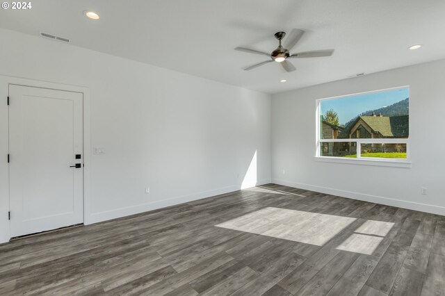 empty room with ceiling fan and dark hardwood / wood-style flooring