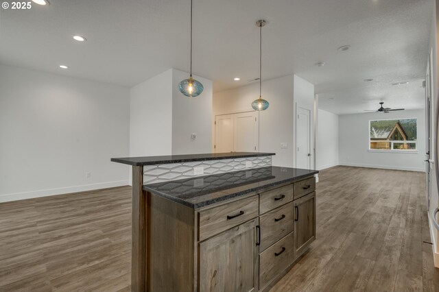 kitchen featuring appliances with stainless steel finishes, plenty of natural light, a kitchen island, and hanging light fixtures