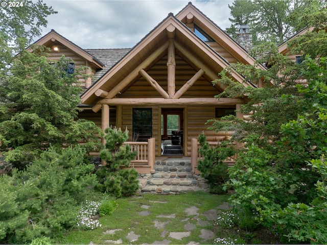 view of front facade with a porch and a chimney