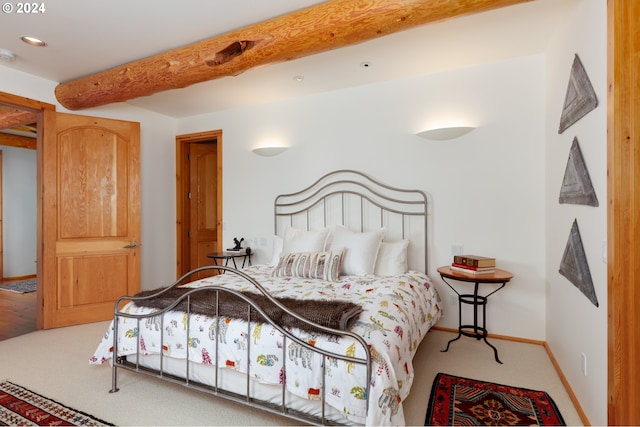 carpeted bedroom with beamed ceiling and baseboards