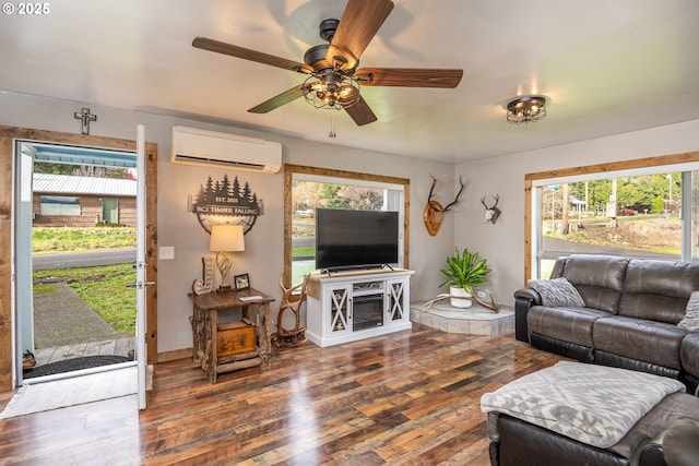 living room with ceiling fan, dark wood-type flooring, a wealth of natural light, and a wall mounted AC