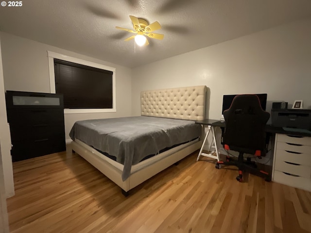 bedroom with a textured ceiling, light hardwood / wood-style floors, and ceiling fan