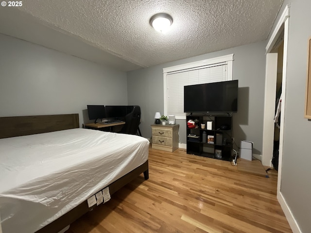 bedroom with a textured ceiling and hardwood / wood-style flooring