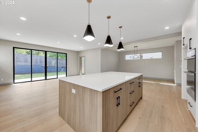 kitchen with a kitchen island, light wood-style flooring, light countertops, modern cabinets, and open floor plan