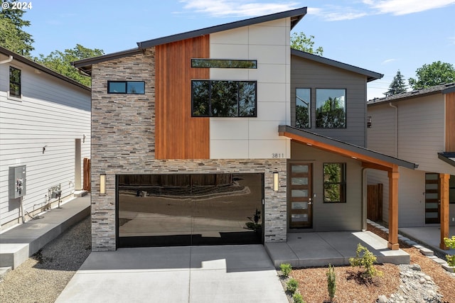 exterior space featuring a garage, stone siding, and driveway