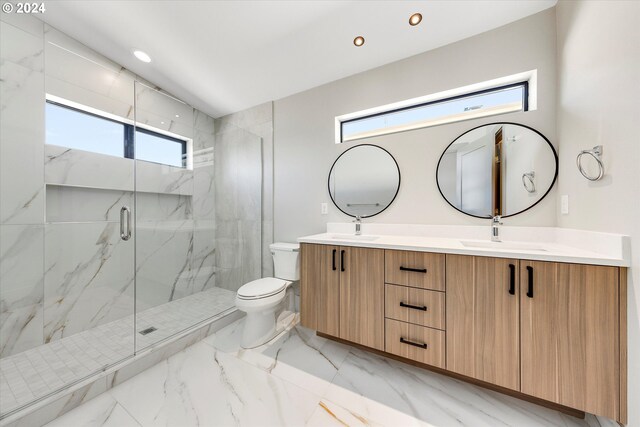 bathroom featuring toilet, marble finish floor, a marble finish shower, and a sink