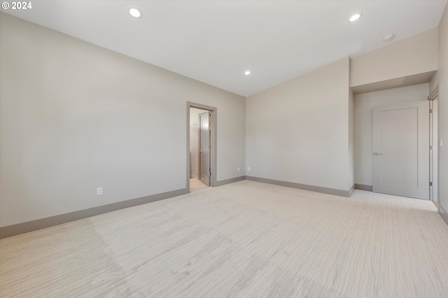 spare room featuring recessed lighting and baseboards