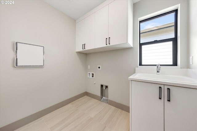 washroom with baseboards, washer hookup, cabinet space, hookup for an electric dryer, and a sink