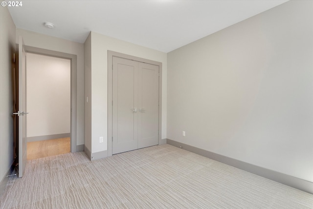 unfurnished bedroom featuring a closet, baseboards, and carpet