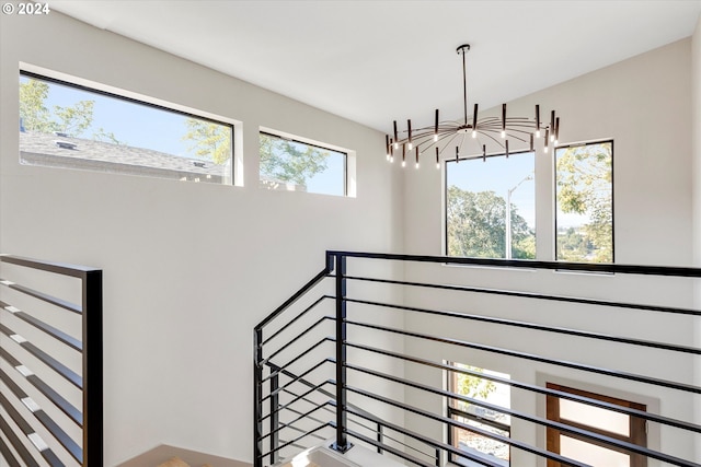 staircase with an inviting chandelier