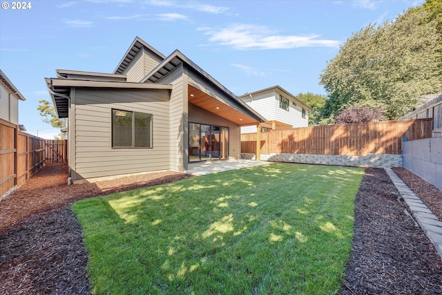 back of property featuring a patio area, a lawn, and a fenced backyard