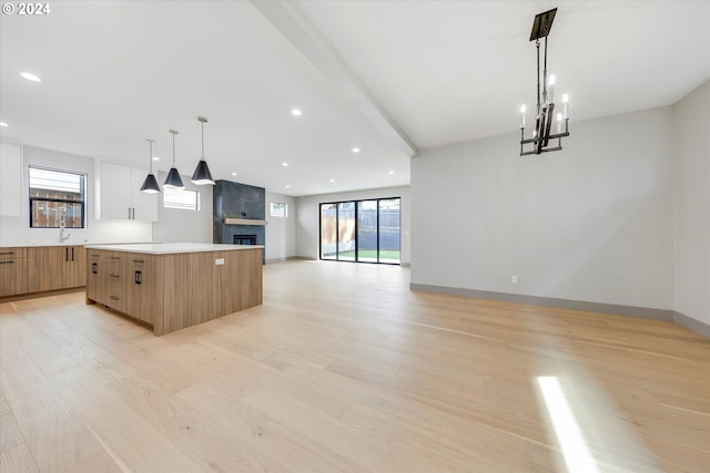 kitchen featuring modern cabinets, plenty of natural light, open floor plan, a center island, and light wood-style floors