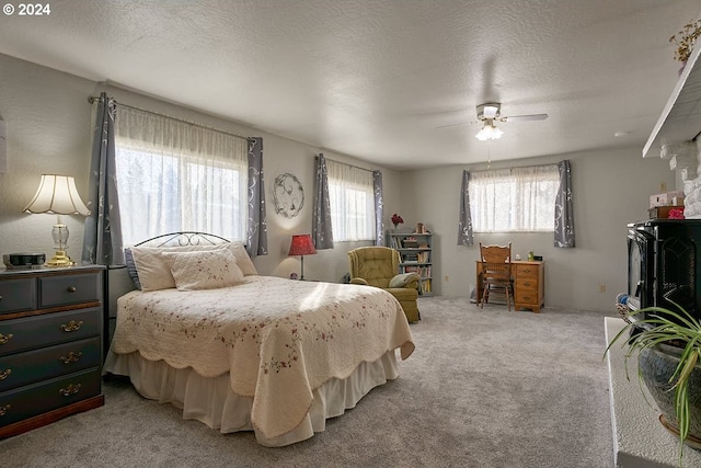 bedroom featuring carpet flooring, ceiling fan, and a textured ceiling