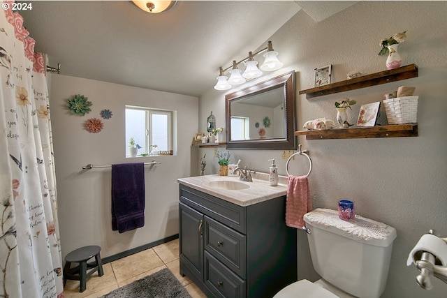 bathroom with tile patterned floors, walk in shower, vanity, and toilet