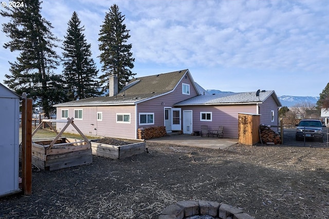 rear view of property with a mountain view and a patio area