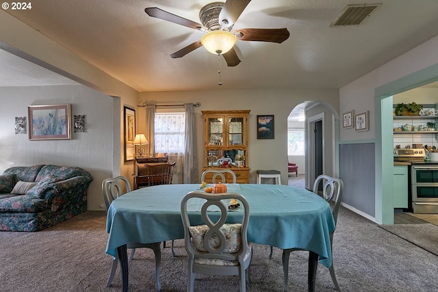 carpeted dining area featuring a textured ceiling and ceiling fan