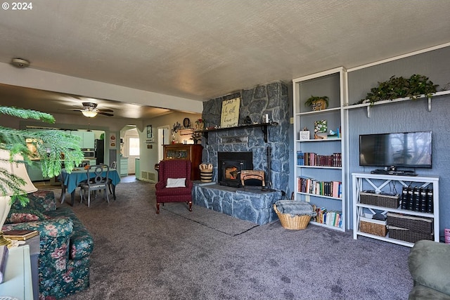 living room with a fireplace, a textured ceiling, carpet floors, and ceiling fan