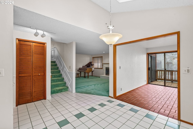 foyer entrance with a textured ceiling and a brick fireplace