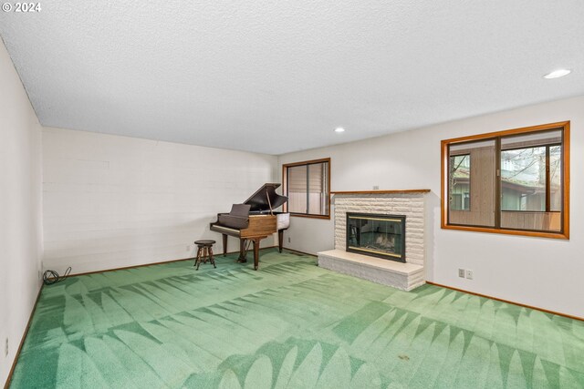 interior space featuring a fireplace, a textured ceiling, and carpet floors