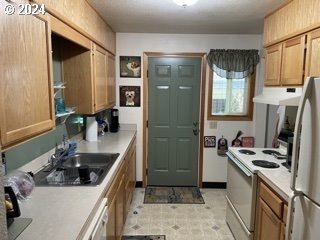 11018 E Burnside St, Portland, OR 97216 - kitchen with extractor fan, white electric range oven, freestanding refrigerator, a sink, and light countertops
