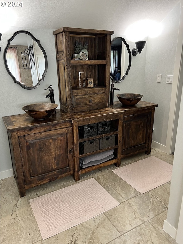 bar with dark brown cabinetry and sink