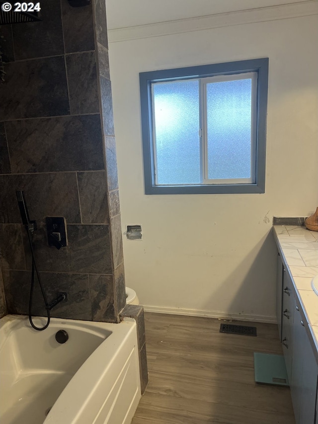 bathroom featuring vanity, wood-type flooring, and tiled shower / bath combo