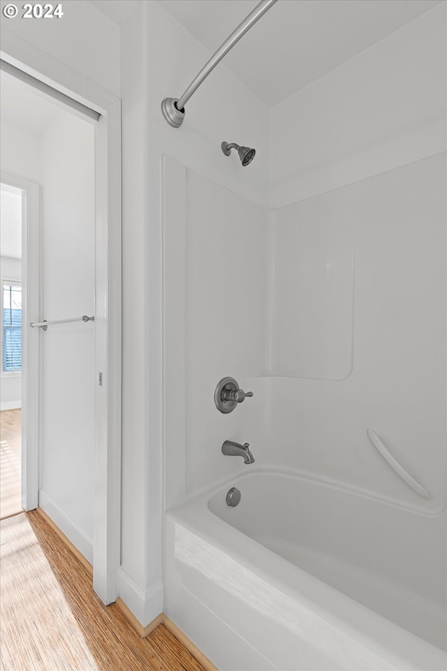 bathroom with hardwood / wood-style flooring and shower / bath combination