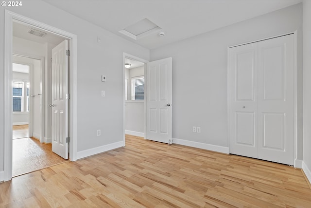 unfurnished bedroom featuring light wood-type flooring and a closet