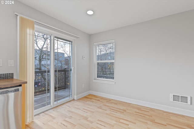 empty room with light wood-type flooring and indoor bar