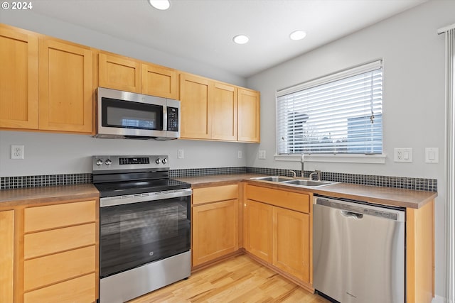 kitchen featuring light brown cabinetry, stainless steel appliances, light hardwood / wood-style flooring, and sink